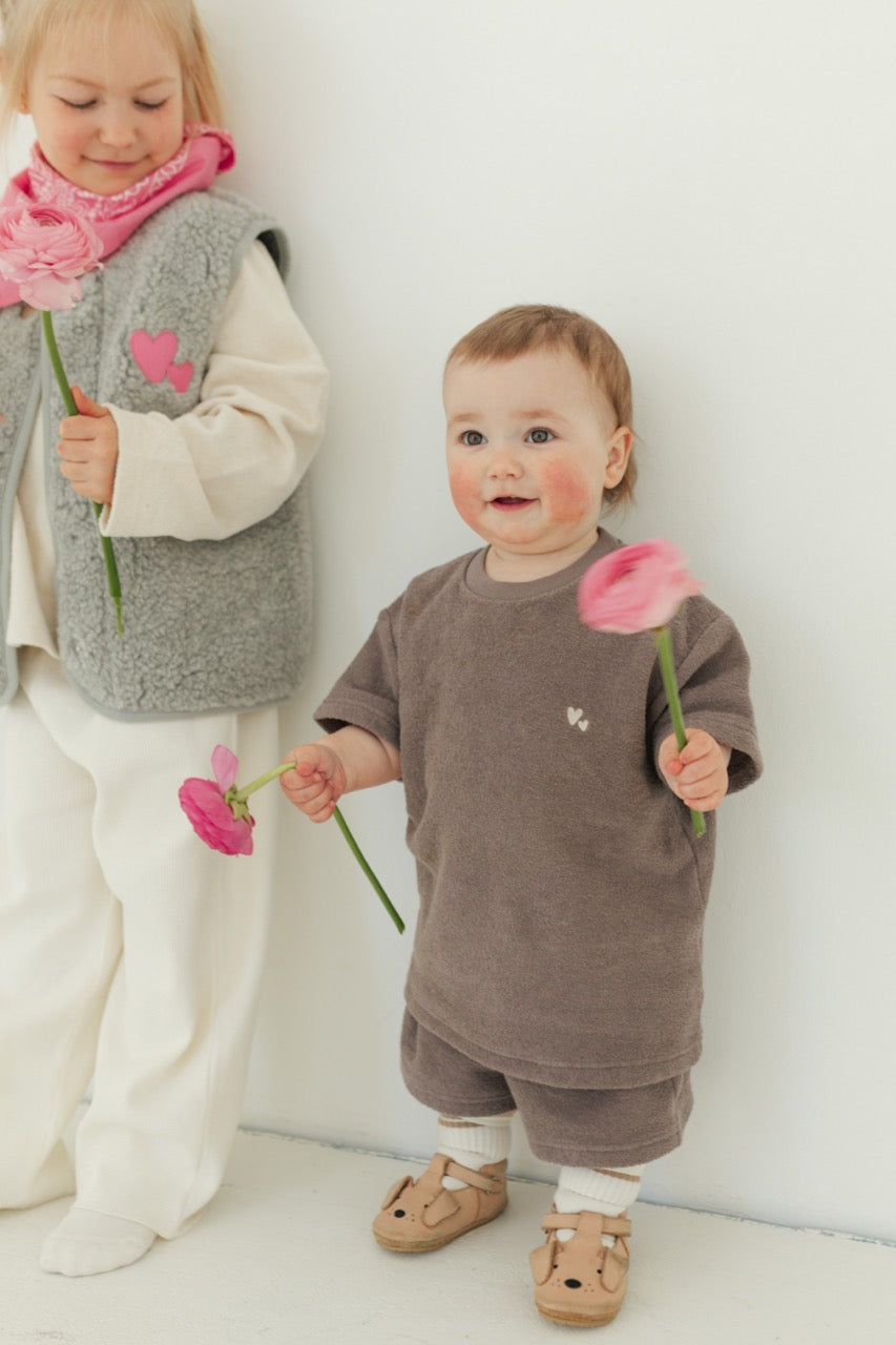 Zwei kleine Mädchen mit Blumen in der Hand