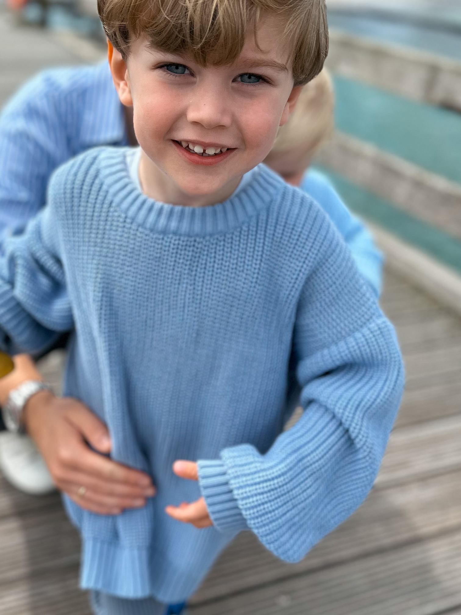 Junge in blauem Strickpullover Partnerlook mit Papa