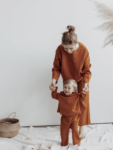 Mother and son in Atelier Rive Matching Pants Cinnamon, walking on her hands