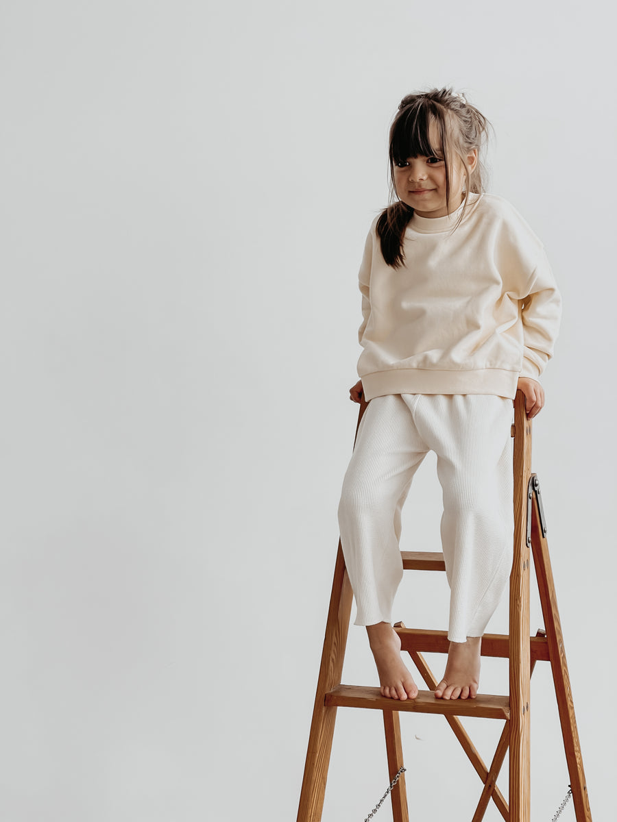 Girl on ladder with Atelier Rive Boxy Sweater and Matching Pants with Ponytail